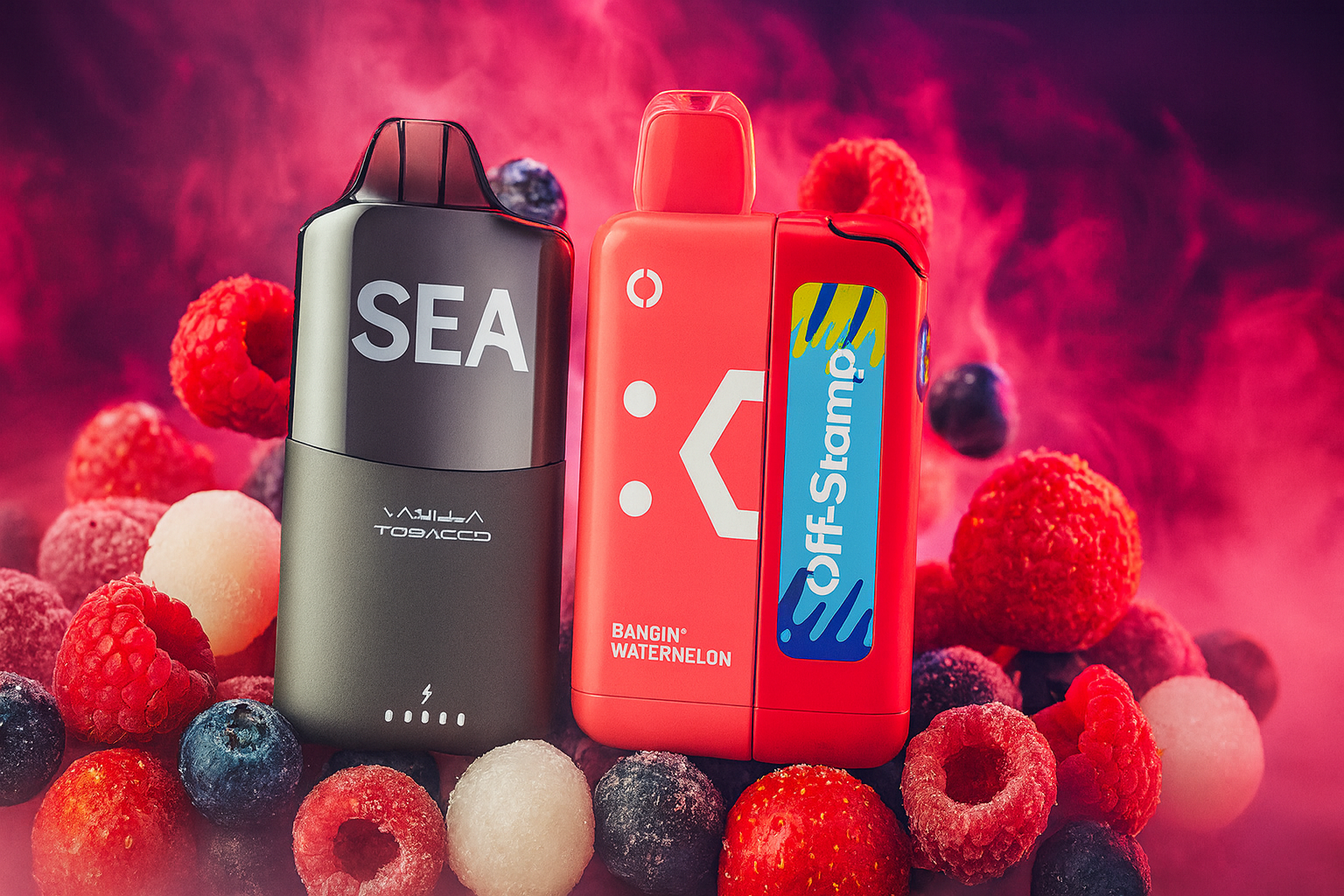 The image features two vape devices surrounded by frozen berries like raspberries, blueberries, and lychee, set against a vivid pink and purple smoky background. The black device on the left is labeled 